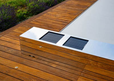 Habillage "effet Miroir" avec panneaux solaires intégrés, assurant l’alimentation d’une couverture automatique de piscine.