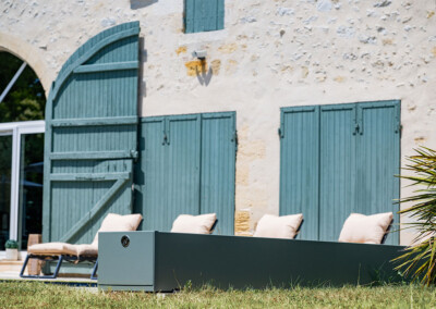 Gros plan sur le coffre de la Coverseal grise, design et discret, parfaitement intégré dans la terrasse.